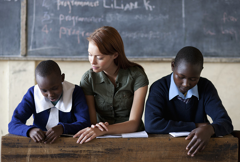 肯尼亚，两名学生和老师坐在教室里看书图片下载