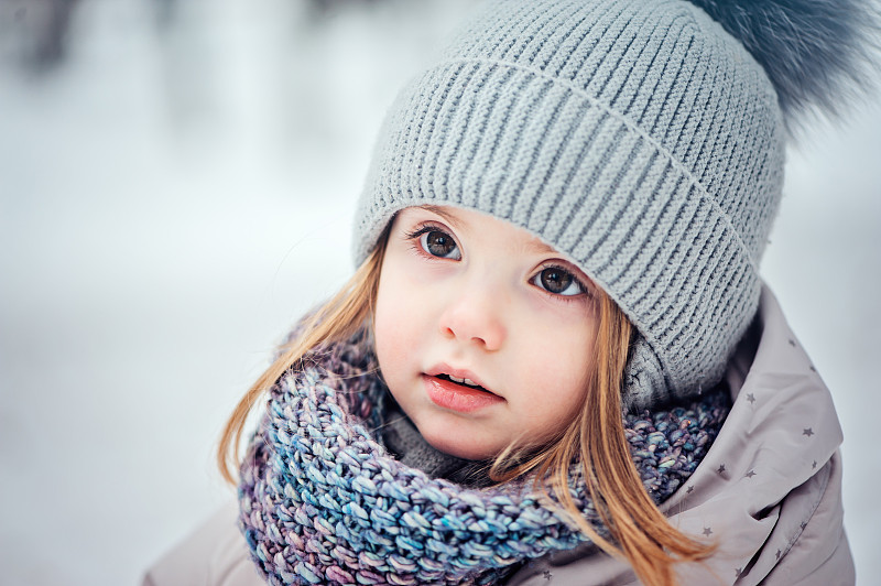 快乐的小女孩在雪地里散步图片下载