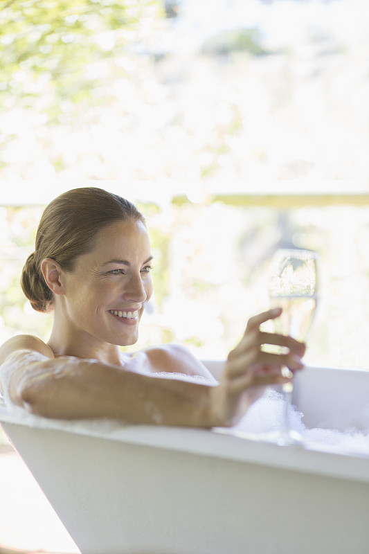 在浴缸里喝香槟的女人图片素材