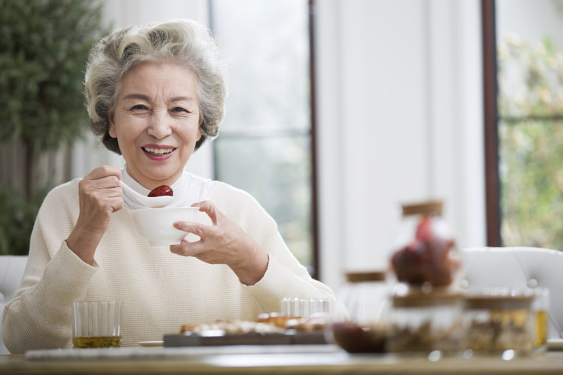 快乐的老年女子吃早餐图片素材