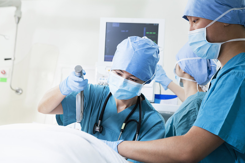 两个外科医生在手术台上工作，手里拿着手术设备图片下载