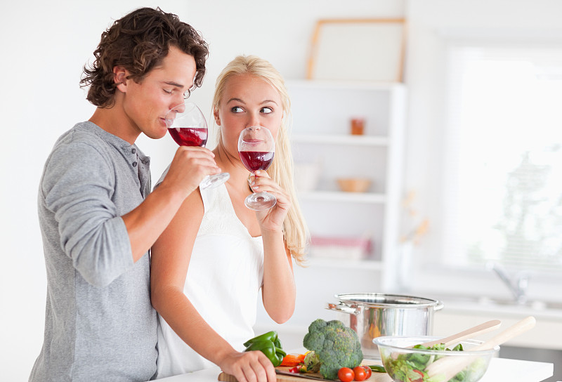 一对夫妇在厨房里喝着红酒图片下载