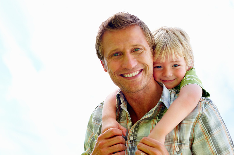 微笑的父亲背着他的儿子背对白色图片下载