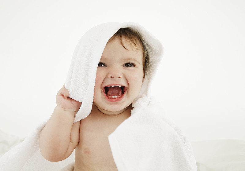 微笑的婴儿裹在毛巾里图片下载