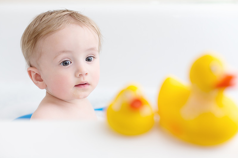 浴缸里的婴儿看着两只橡皮鸭图片下载