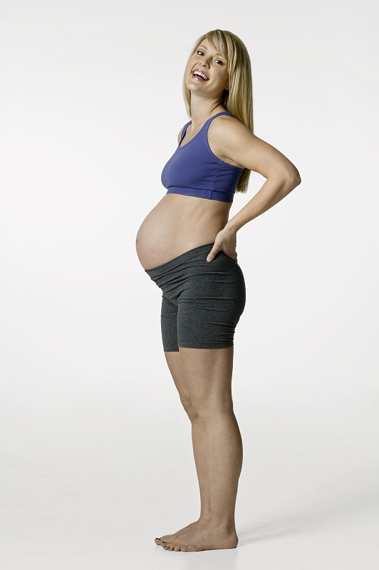 一个年轻孕妇在摄影棚里摆姿势图片下载