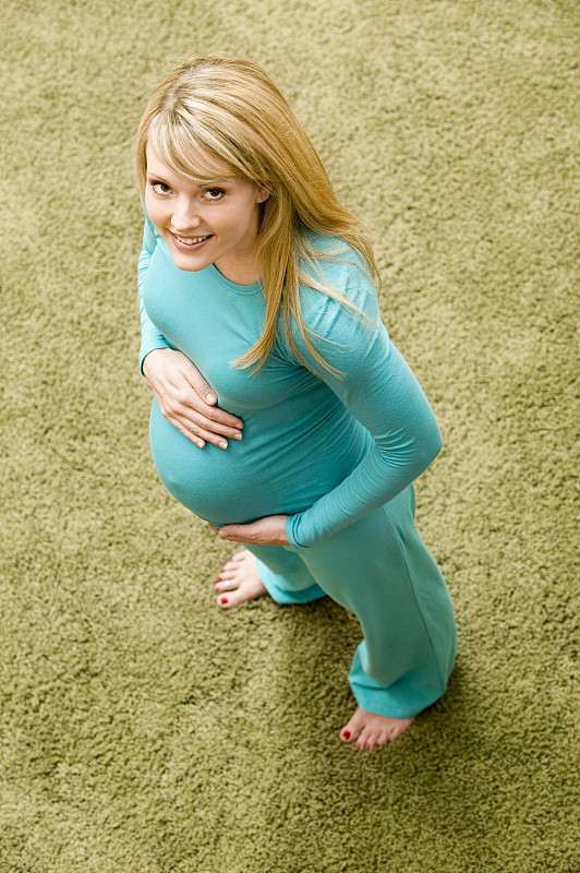孕妇站在地毯上，居高临下图片下载