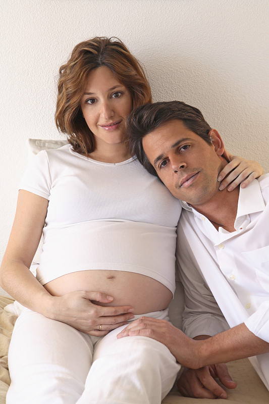 男人和孕妇坐在床上，画像图片下载