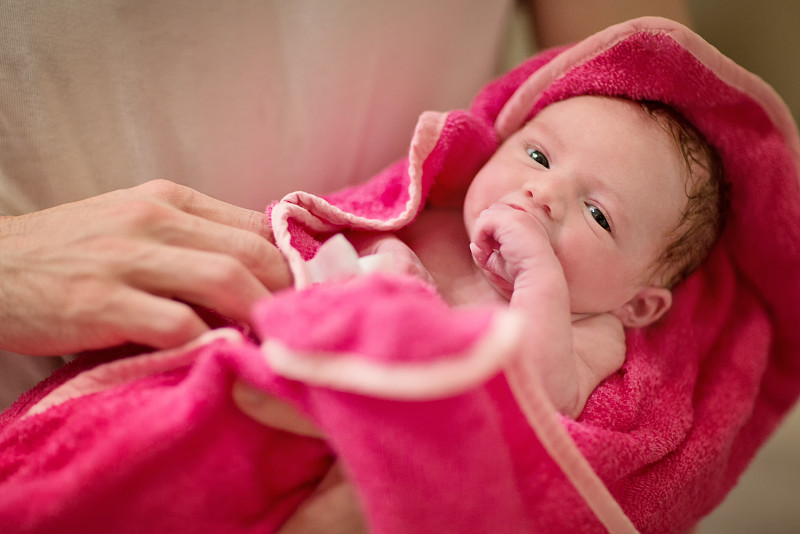 刚出生的女婴沐浴后裹在毛巾里图片下载