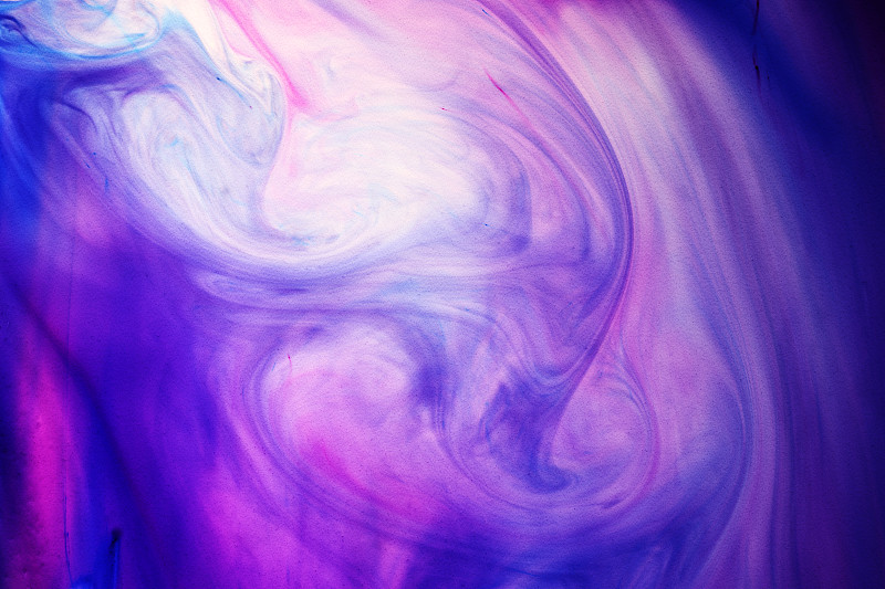 蓝色和紫色染料在液体中旋转图片下载