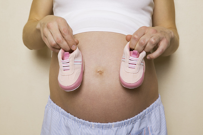 一个孕妇拿着一双鞋的剖面图图片下载