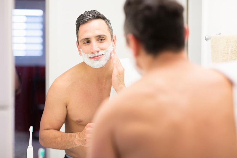 中年男子，照镜子，往脸上抹剃须泡沫，后视镜图片下载