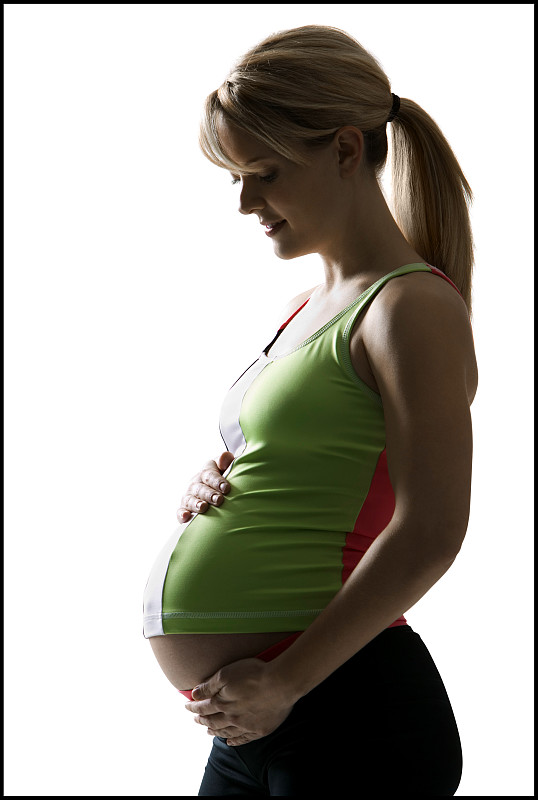孕妇的侧面触摸她的腹部图片下载
