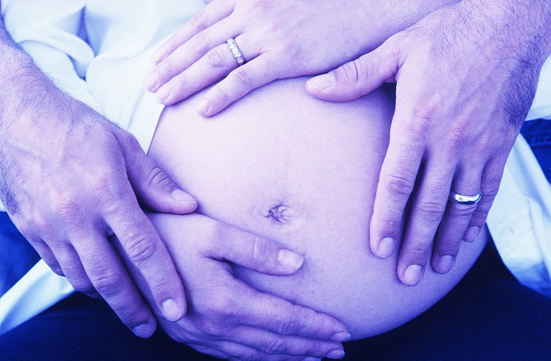 一个男人的手握着一个孕妇的肚子图片下载