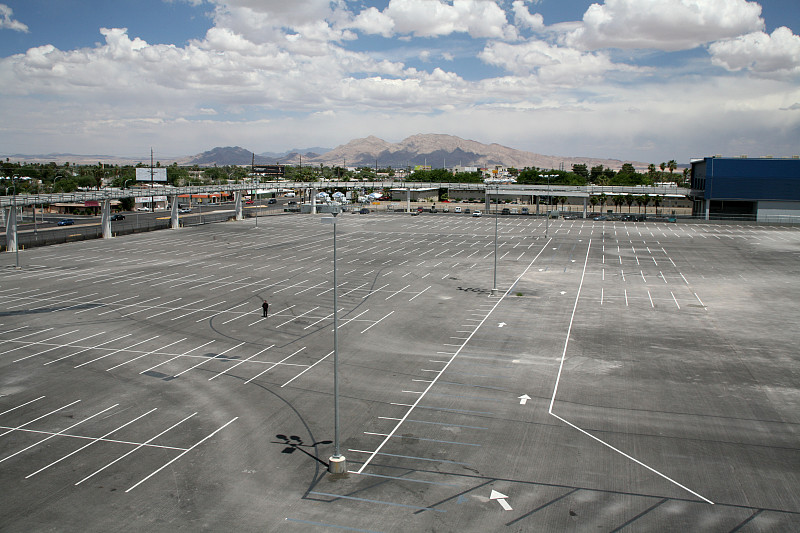 一个男人站在一个空停车场的中央图片下载