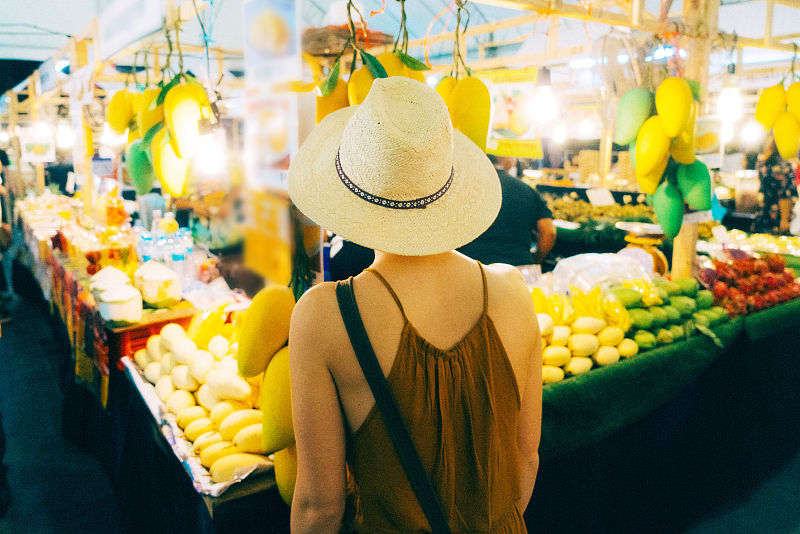 在市场上挑选芒果的女人图片素材