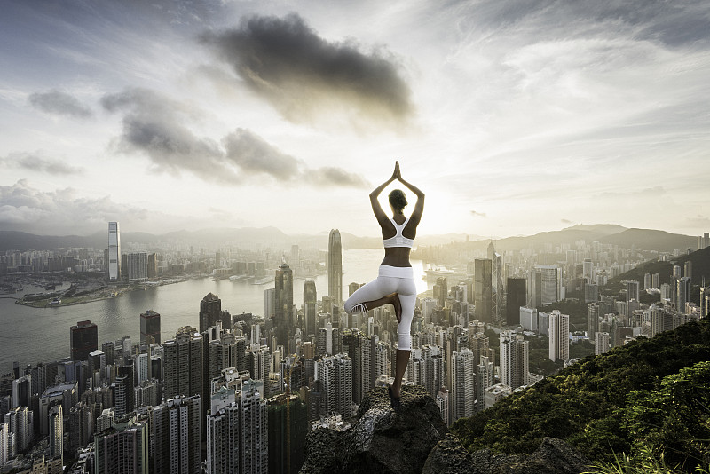 年轻女子在香港前练习瑜伽图片下载