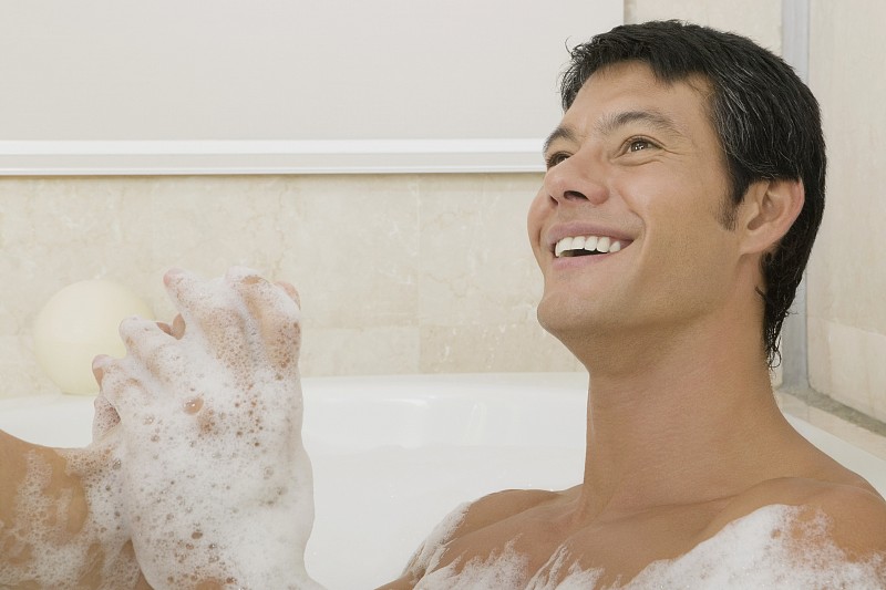 一个年轻男子在泡泡浴的特写图片下载
