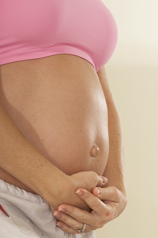 孕妇触摸腹部的中段视图图片下载