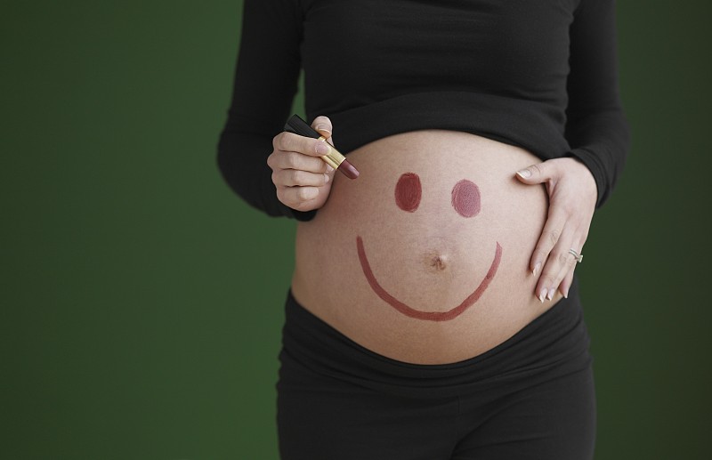 孕妇在裸露的肚子上画笑脸图片下载