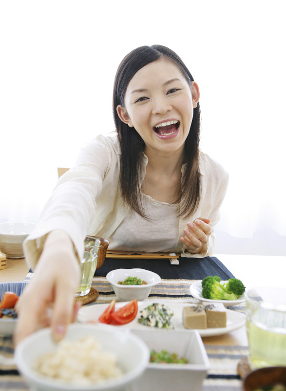 一个日本女人微笑着吃早餐图片下载