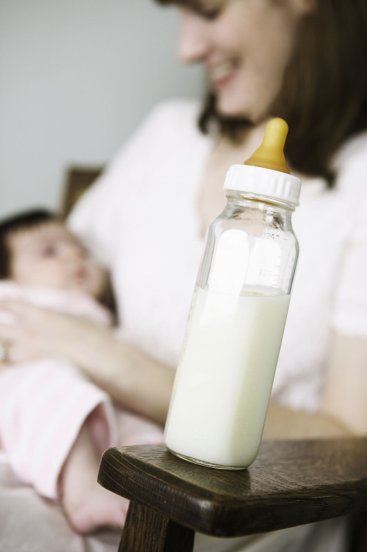 妈妈和宝宝拿着奶瓶图片下载