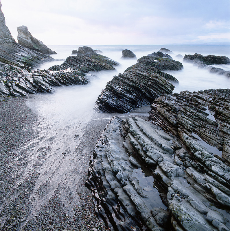 海浪冲击着海滩上的岩层图片下载