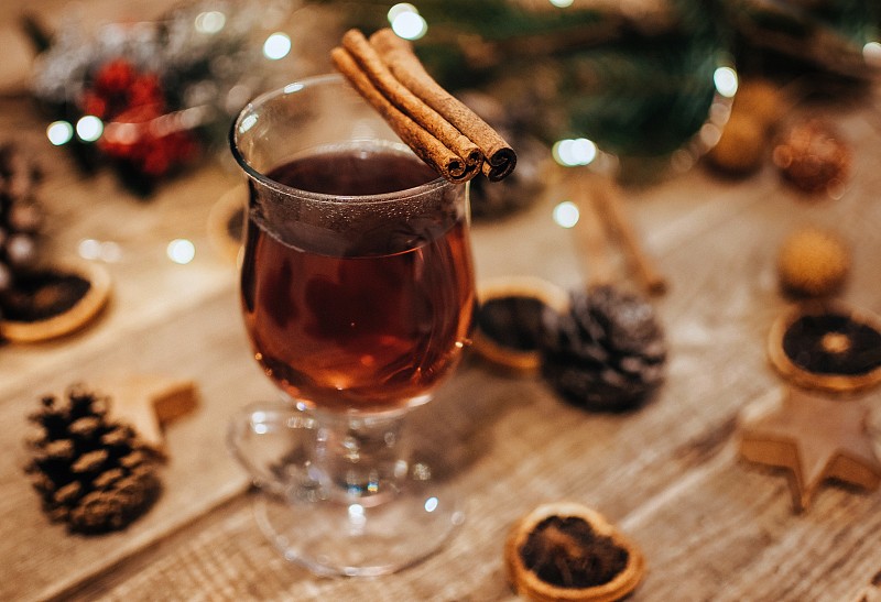 一杯热茶或热葡萄酒在一个木制的背景。选择性对焦，散景灯。图片素材