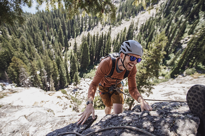 在怀俄明州的提顿山脉，一个年轻人在攀岩时微笑着图片素材