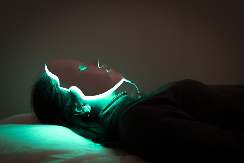 一位年轻女性的LED面膜再生治疗图片素材