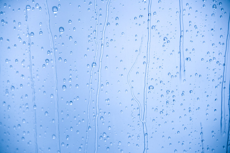 雨点落在透明的玻璃窗上。平面设计的概念背景。图片素材