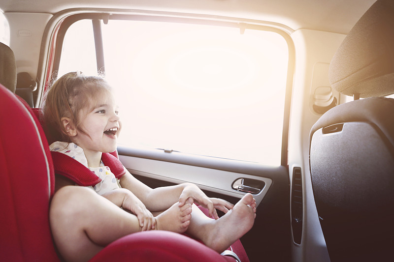 可爱的小女孩在汽车安全座椅微笑图片素材