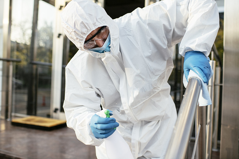 男子用手套和消毒液擦拭消毒，防止细菌和细菌感染图片下载