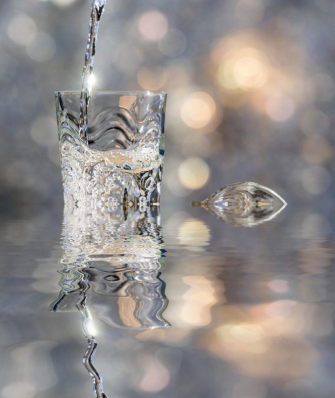 一杯水晶与水的冲击，落在水中反射。图片下载