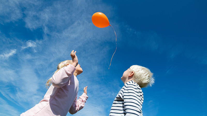 孩子们在蓝天中放飞气球图片素材