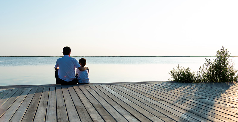 父亲和儿子一起欣赏湖景图片下载