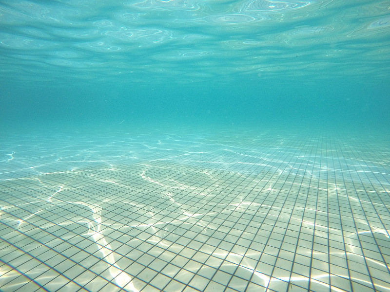 游泳池地板与阳光反射水下视图。图片素材