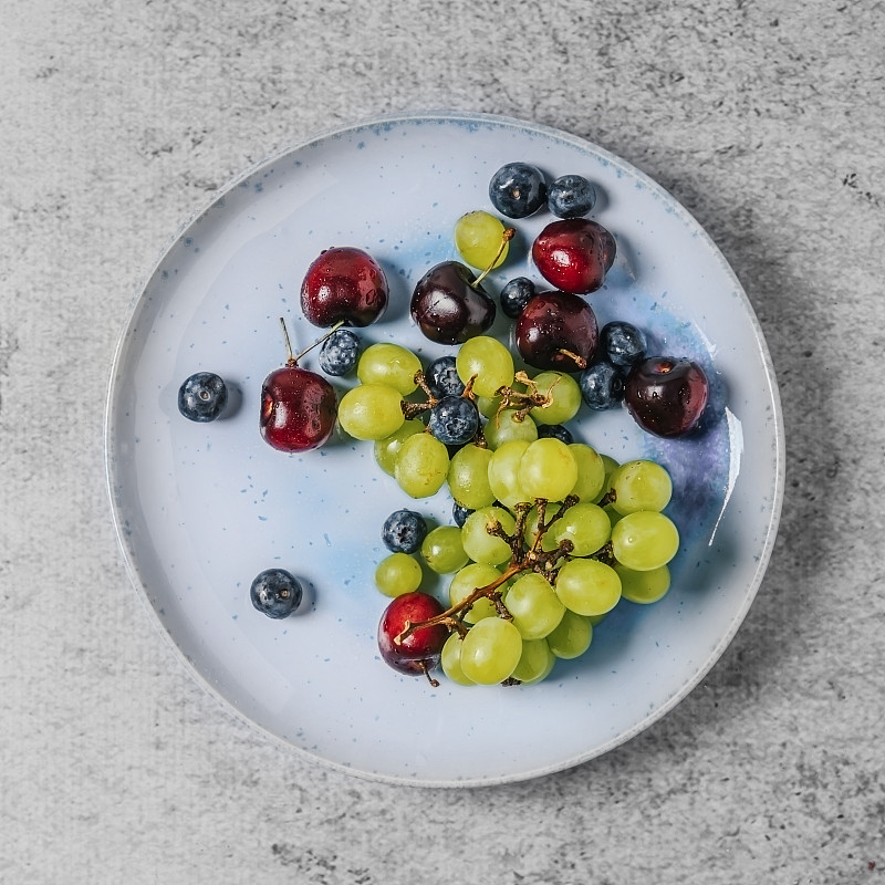 灰色背景上的各种水果(葡萄、樱桃和蓝莓)图片下载