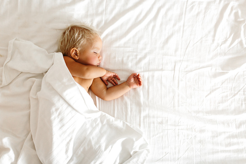 安静的婴儿躺在床上，在明亮的房间里睡觉图片下载