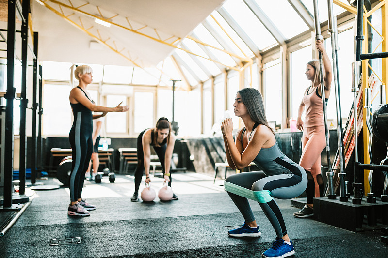 女性健身教练在健身房和一群女性一起工作图片素材