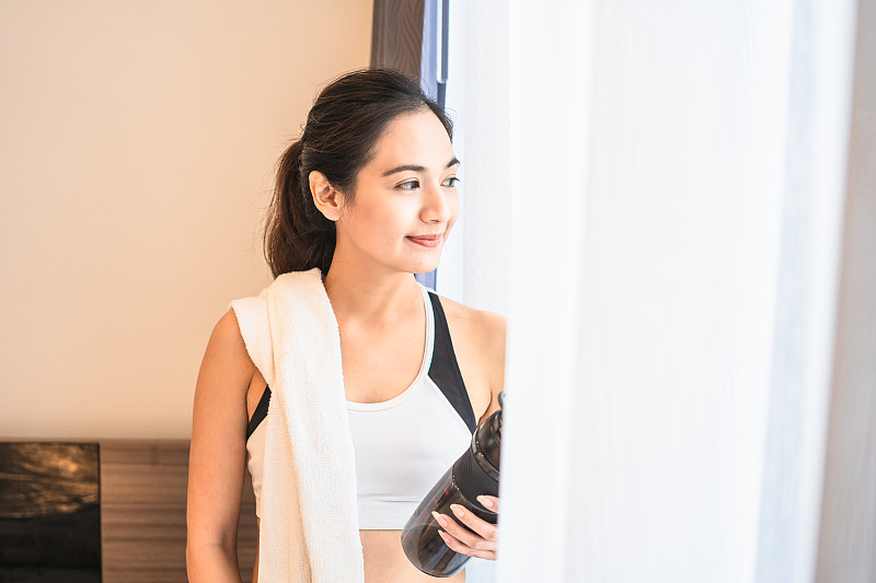 亚洲妇女微笑后，独自锻炼在家作为新的正常生活方式图片下载