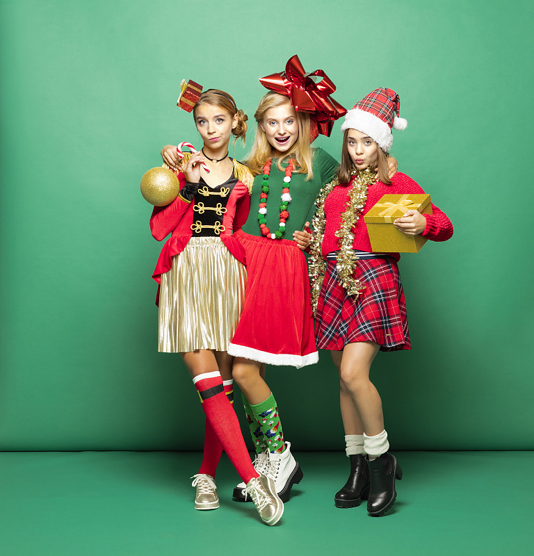 有趣的圣诞肖像三个十几岁的女孩在绿色的背景图片素材