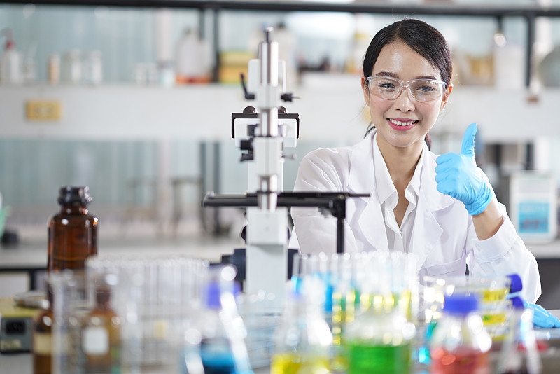 年轻自信的女科学家坐在化学实验室的肖像图片下载