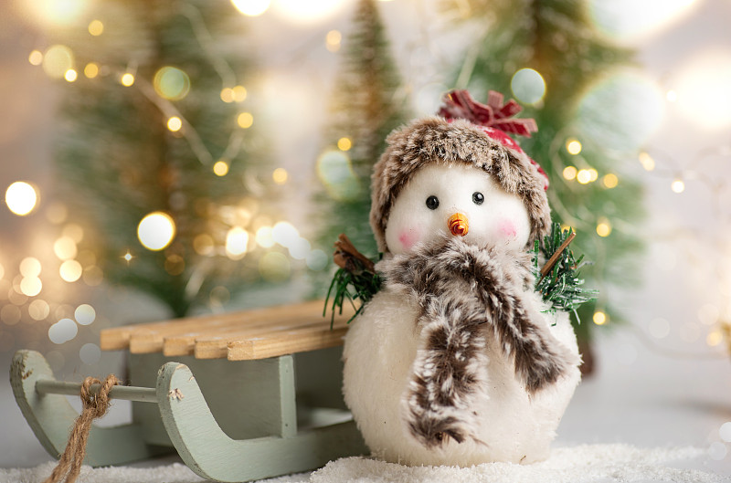玩具雪人和冬季节日符号和玩具闪亮的节日仙女灯图片下载