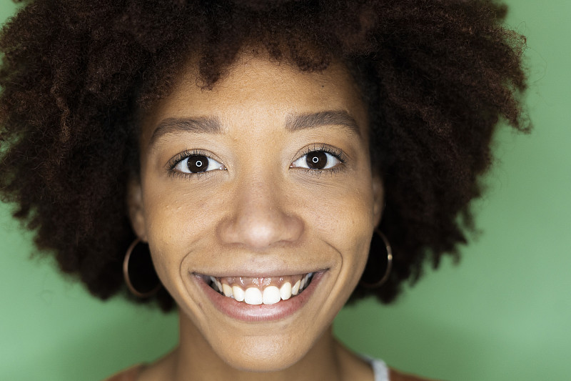 在新的阁楼公寓里，快乐的非洲裔妇女靠在绿色的墙上图片下载