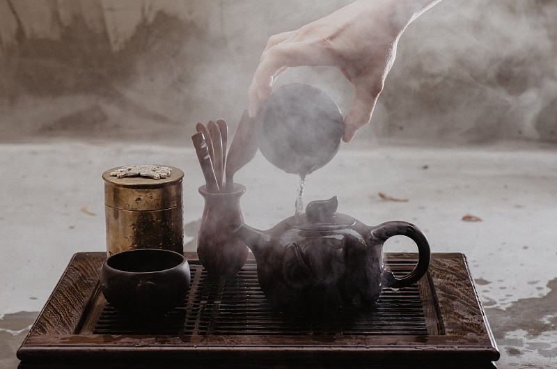 一名妇女用中国传统茶具倒茶的镜头图片下载