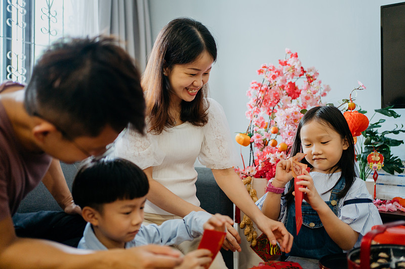 一个亚洲家庭在客厅里准备春节红包图片下载