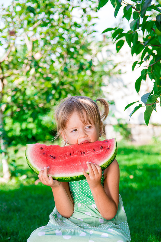 孩子在花园里吃西瓜，夏天在公园里图片下载