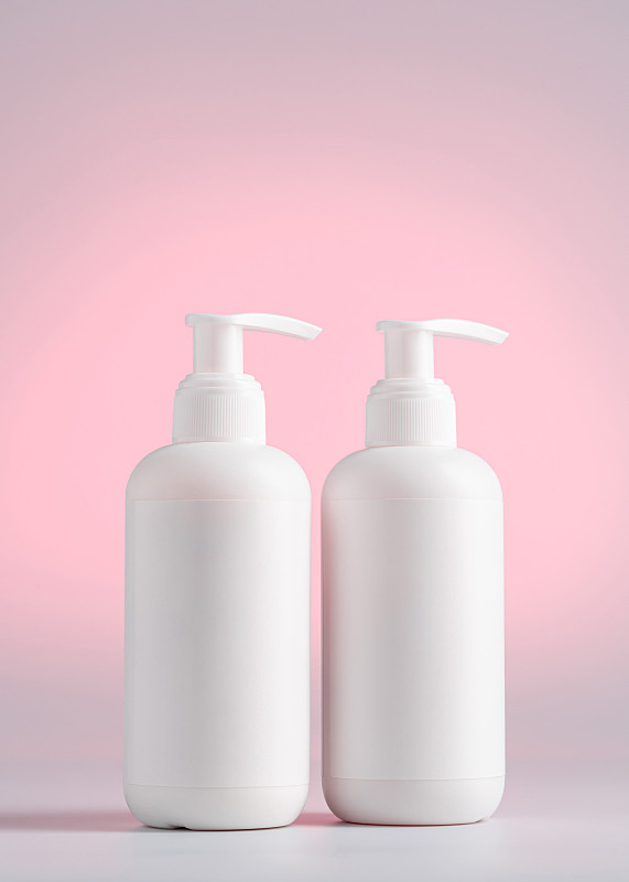 空白白瓶洗发水，模拟包装在粉红色的光背景，包装洗发水没有标志和标签图片下载