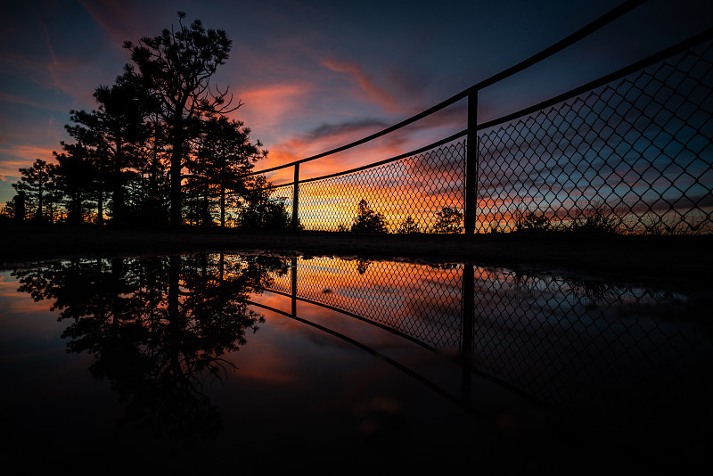 剪影树篱笆对天空在日落摄影图片